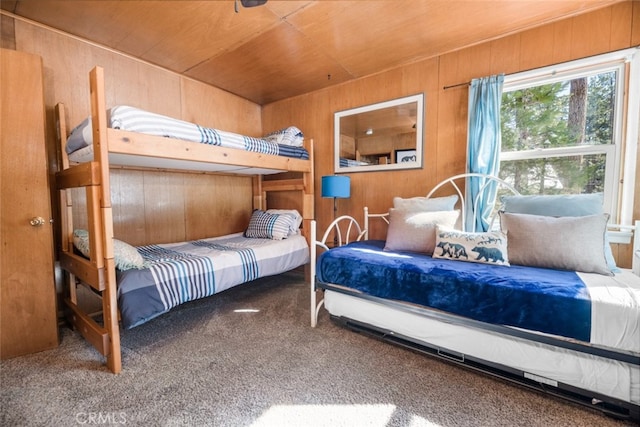 carpeted bedroom with wood walls and wood ceiling
