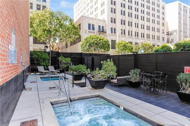 view of pool featuring a hot tub, fence private yard, and a patio