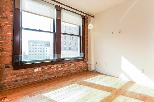 spare room with baseboards and wood finished floors