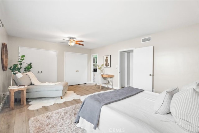 bedroom with a ceiling fan, baseboards, visible vents, and wood finished floors