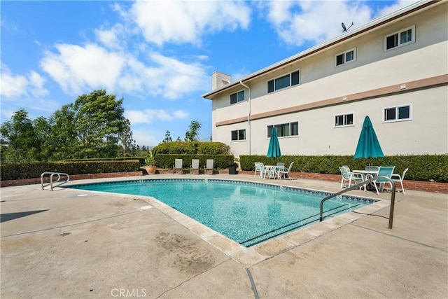 pool with a patio and outdoor dining space