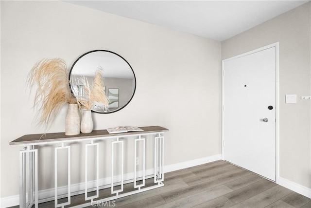 foyer featuring baseboards and wood finished floors