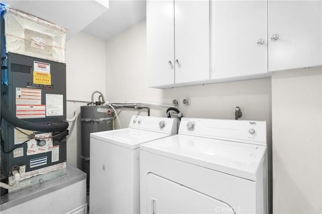 clothes washing area featuring cabinet space, water heater, washer and clothes dryer, and heating unit
