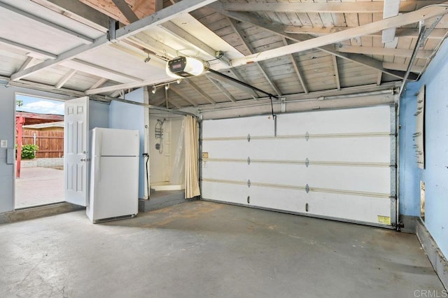 garage with freestanding refrigerator and a garage door opener