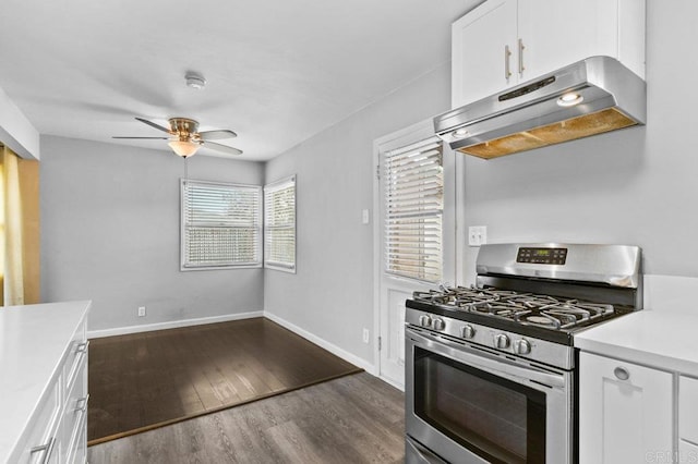 kitchen featuring under cabinet range hood, stainless steel gas range, ceiling fan, white cabinetry, and light countertops