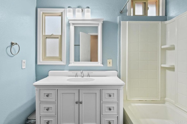 full bathroom featuring vanity, shower / washtub combination, and a textured wall