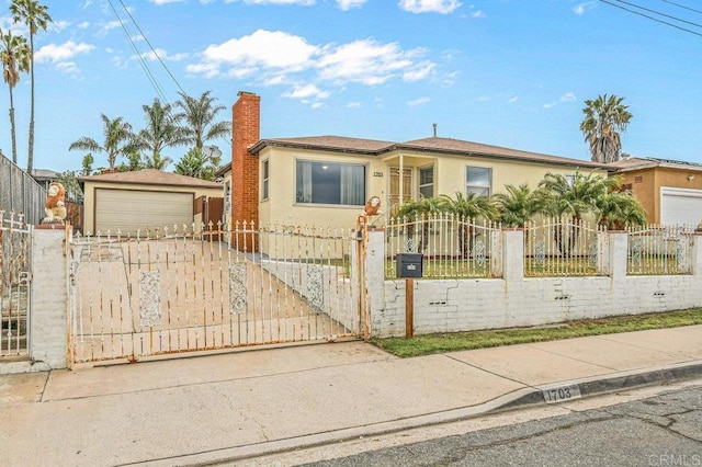 view of front of home with a chimney, a fenced front yard, stucco siding, concrete driveway, and a gate