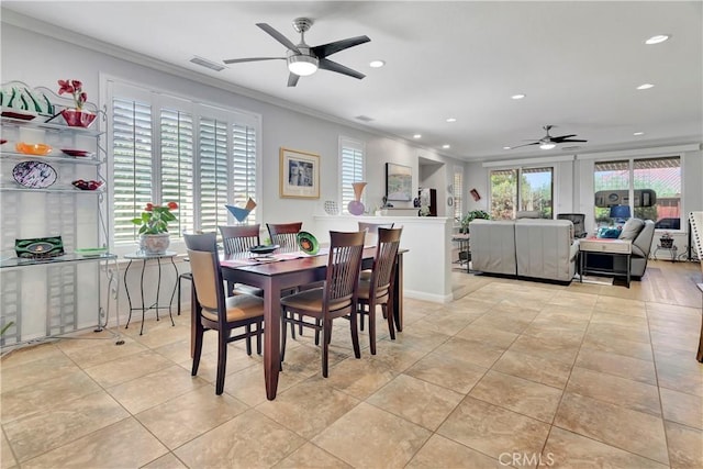 dining space with a healthy amount of sunlight, ceiling fan, ornamental molding, and visible vents