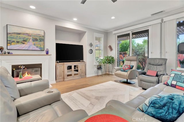 living area with ornamental molding, visible vents, recessed lighting, and wood finished floors