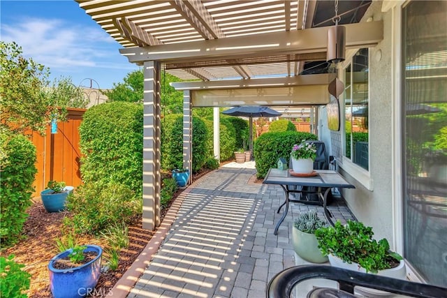view of patio with a pergola and fence