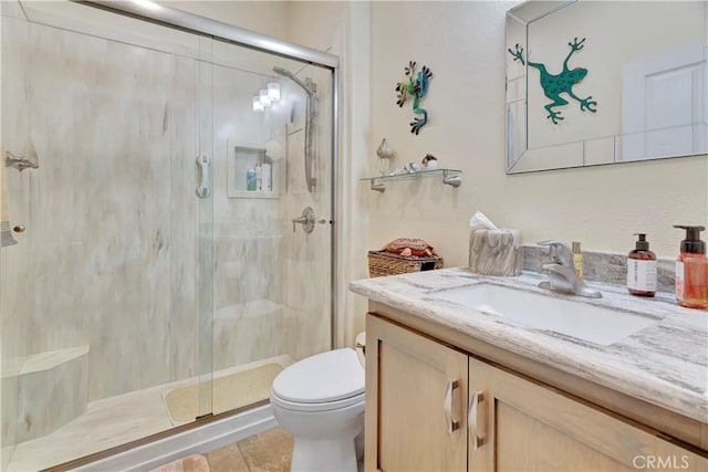 bathroom with a stall shower, vanity, and toilet