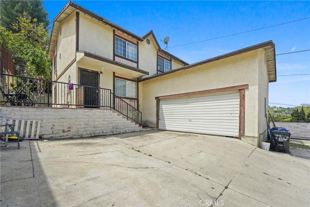 49604962 Gambier St, Los Angeles, CA 90032 - view of front facade featuring stucco siding, an attached garage, fence, and concrete driveway