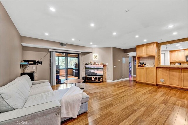 living area featuring light wood finished floors, recessed lighting, and baseboards
