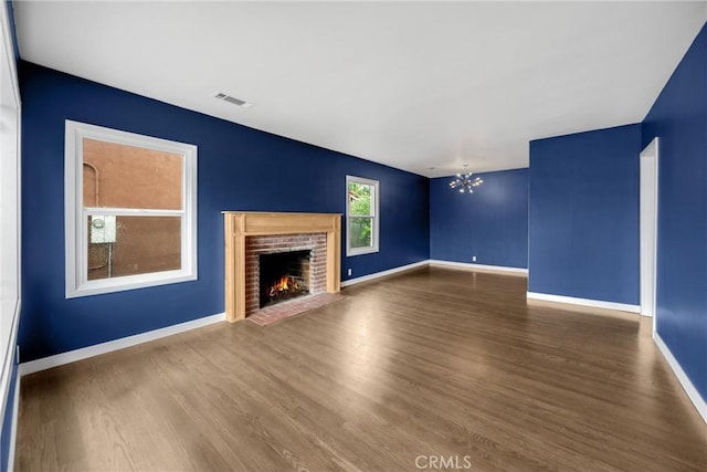 13023 Woodcock Ave, Sylmar, CA 91342 - unfurnished living room featuring wood finished floors, baseboards, a brick fireplace, and a chandelier