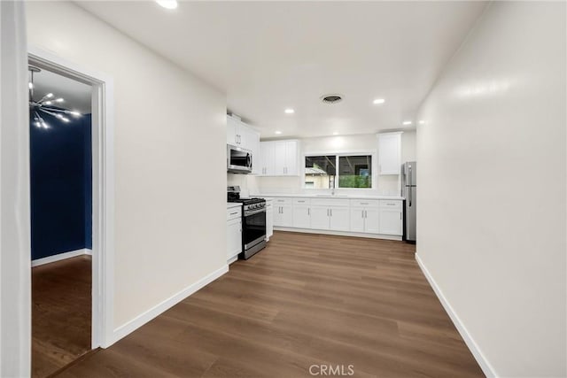 13023 Woodcock Ave, Sylmar, CA 91342 - kitchen featuring appliances with stainless steel finishes, white cabinets, baseboards, dark wood finished floors, and recessed lighting
