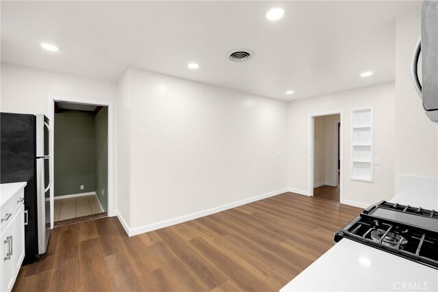 13023 Woodcock Ave, Sylmar, CA 91342 - kitchen featuring freestanding refrigerator, white cabinets, dark wood-type flooring, recessed lighting, and light countertops