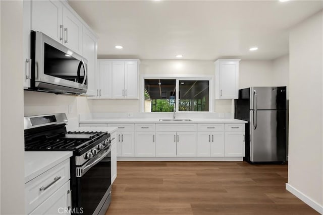 13023 Woodcock Ave, Sylmar, CA 91342 - kitchen featuring appliances with stainless steel finishes, white cabinetry, light countertops, a sink, and recessed lighting