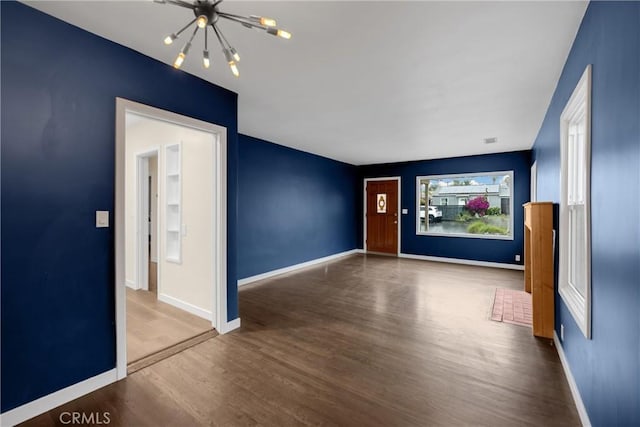 13023 Woodcock Ave, Sylmar, CA 91342 - empty room with a chandelier, wood finished floors, and baseboards