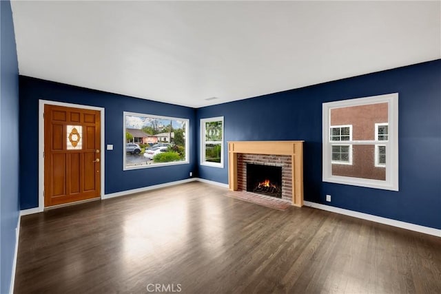 13023 Woodcock Ave, Sylmar, CA 91342 - unfurnished living room with wood finished floors, a brick fireplace, and baseboards