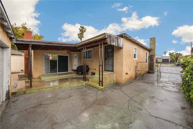 13023 Woodcock Ave, Sylmar, CA 91342 - back of property featuring a gate, a chimney, stucco siding, and a patio area
