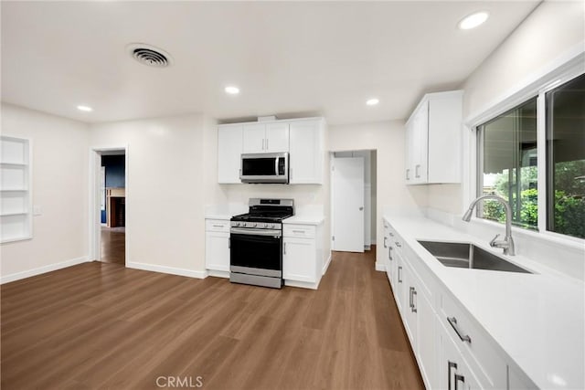 13023 Woodcock Ave, Sylmar, CA 91342 - kitchen featuring appliances with stainless steel finishes, a sink, light countertops, white cabinetry, and recessed lighting