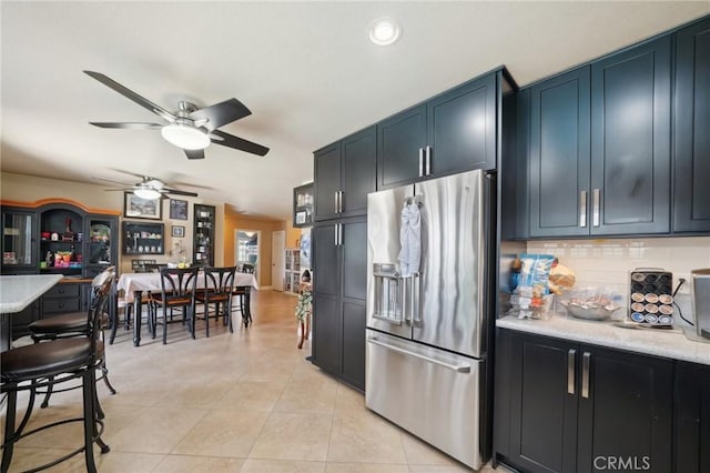 6253 Hamilton Ct, Chino, CA 91710 - kitchen featuring stainless steel fridge with ice dispenser, a ceiling fan, backsplash, light tile patterned flooring, and dark cabinetry