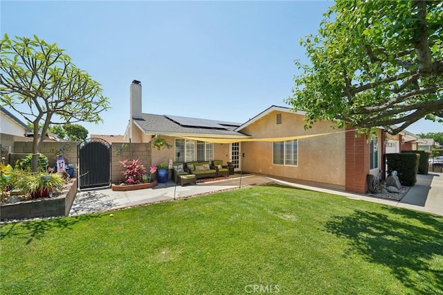 6253 Hamilton Ct, Chino, CA 91710 - rear view of property with a gate, roof mounted solar panels, stucco siding, a patio, and a chimney