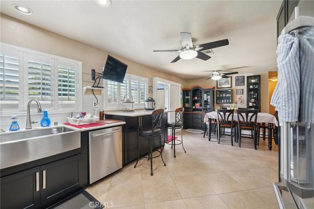 6253 Hamilton Ct, Chino, CA 91710 - kitchen featuring dishwasher, a sink, dark cabinetry, ceiling fan, and light tile patterned floors