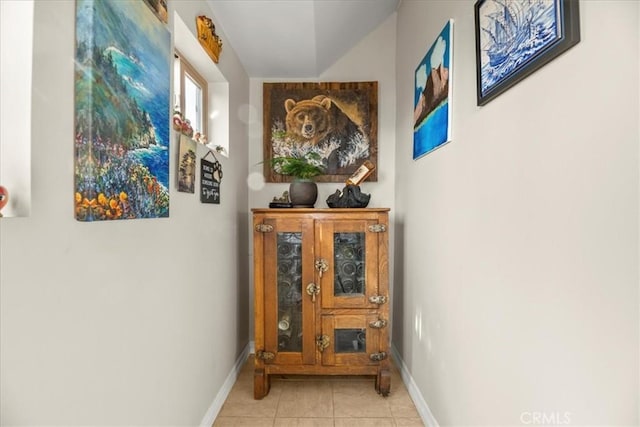 hallway featuring baseboards and light tile patterned floors