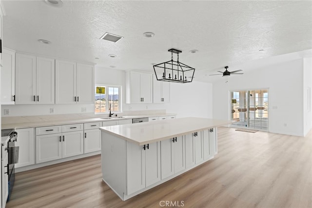 16925 Nanticoke Rd, Apple Valley, CA 92307 - kitchen featuring white cabinets, light wood-type flooring, a center island, and a sink