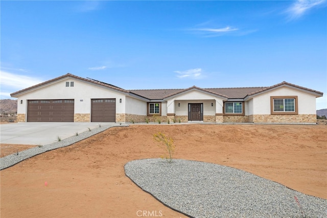 16925 Nanticoke Rd, Apple Valley, CA 92307 - view of front of property with stone siding, stucco siding, an attached garage, and driveway