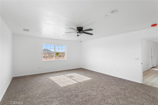 16925 Nanticoke Rd, Apple Valley, CA 92307 - unfurnished room with light colored carpet, visible vents, baseboards, and a ceiling fan