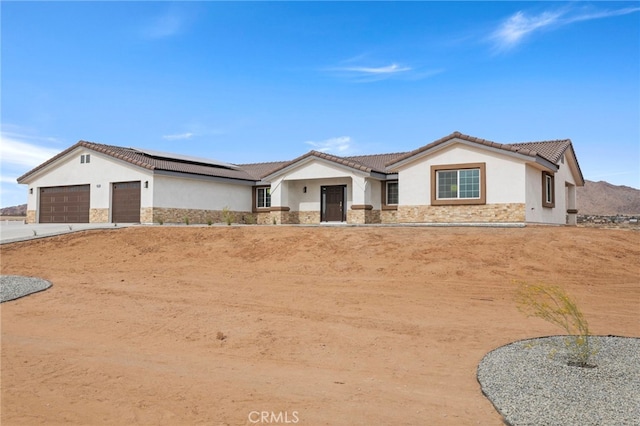 16925 Nanticoke Rd, Apple Valley, CA 92307 - ranch-style home featuring a garage, stucco siding, stone siding, and solar panels
