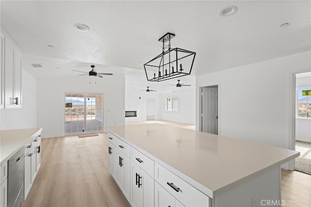16925 Nanticoke Rd, Apple Valley, CA 92307 - kitchen with light wood-type flooring, open floor plan, ceiling fan, and white cabinetry