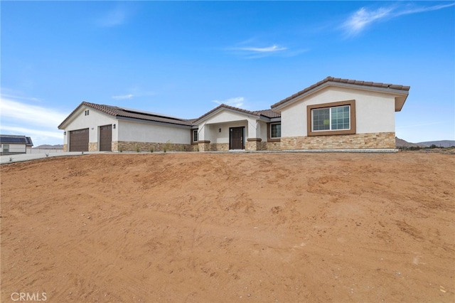16925 Nanticoke Rd, Apple Valley, CA 92307 - ranch-style house featuring stone siding, stucco siding, a tiled roof, and a garage