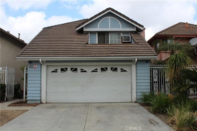 garage featuring concrete driveway and fence