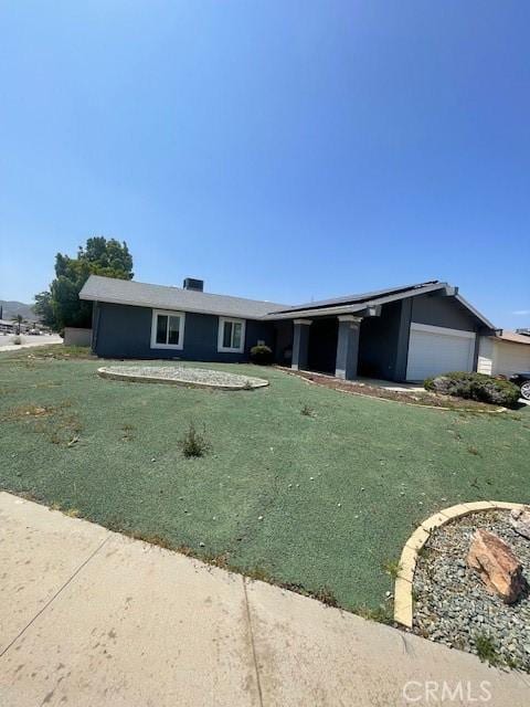 view of front of home featuring a front yard and a garage