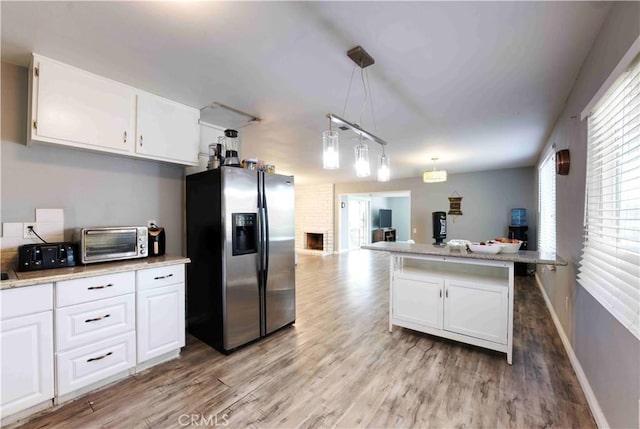 26376 Mahaffey, Menifee, CA 92586 - kitchen featuring stainless steel refrigerator with ice dispenser, light wood-type flooring, white cabinets, open floor plan, and hanging light fixtures