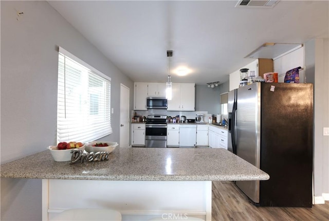 26376 Mahaffey, Menifee, CA 92586 - kitchen featuring stainless steel appliances, white cabinets, light wood finished floors, and decorative light fixtures