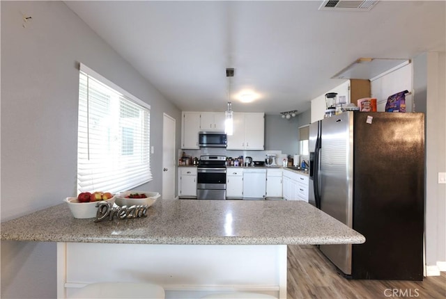 26376 Mahaffey, Menifee, CA 92586 - kitchen with appliances with stainless steel finishes, white cabinets, light wood-style floors, and pendant lighting