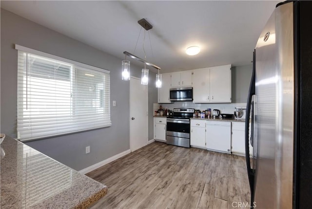 26376 Mahaffey, Menifee, CA 92586 - kitchen with stainless steel appliances, white cabinetry, light wood-style floors, tasteful backsplash, and hanging light fixtures
