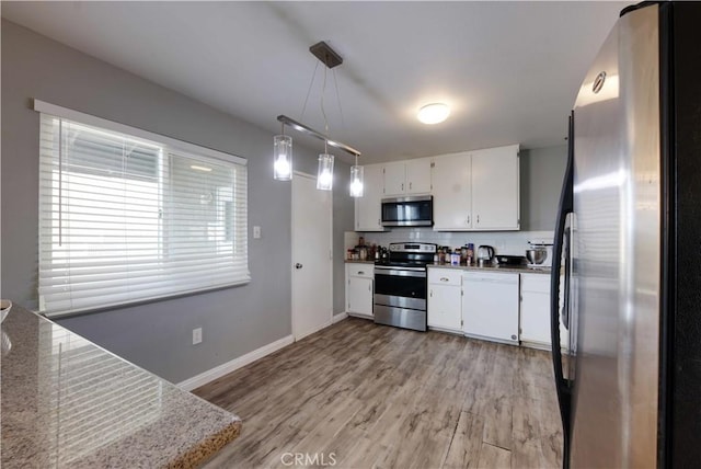 26376 Mahaffey, Menifee, CA 92586 - kitchen with appliances with stainless steel finishes, white cabinetry, light wood finished floors, tasteful backsplash, and pendant lighting