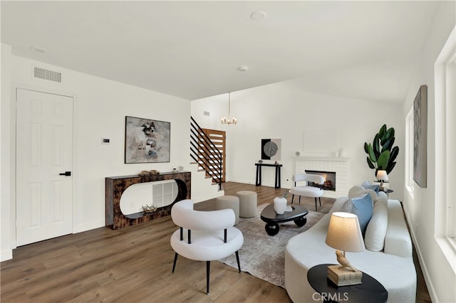 21011 N Hampton Way, Lake Forest, CA 92630 - living area featuring stairs, wood finished floors, lofted ceiling, a chandelier, and a brick fireplace