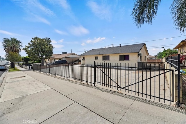 view of front facade with a residential view, stucco siding, and a fenced front yard