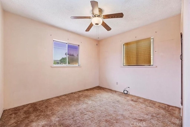 carpeted empty room with ceiling fan and a textured ceiling