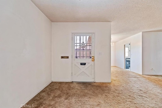 carpeted spare room featuring a textured ceiling and plenty of natural light