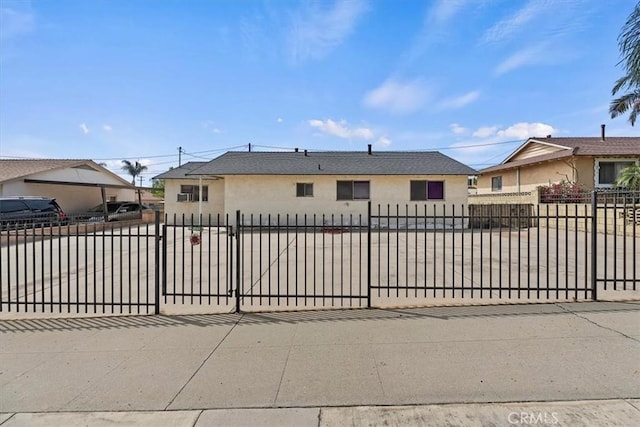 view of front facade featuring concrete driveway, a fenced front yard, and stucco siding