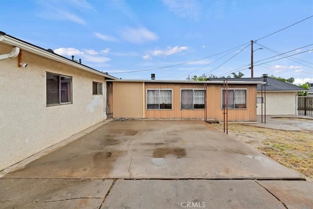 view of side of home with a patio area and fence