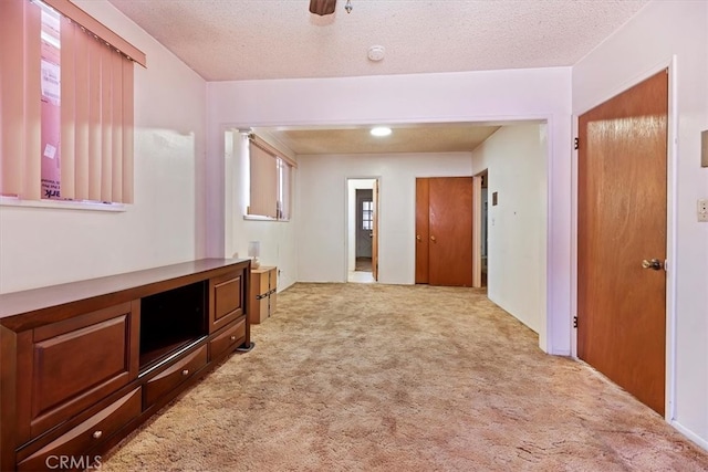 hall featuring a textured ceiling and carpet