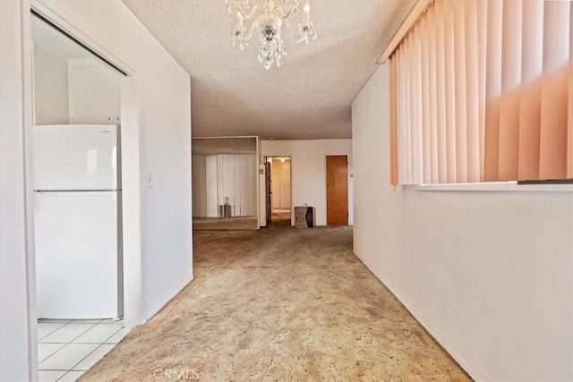 corridor featuring carpet, an inviting chandelier, and a textured ceiling